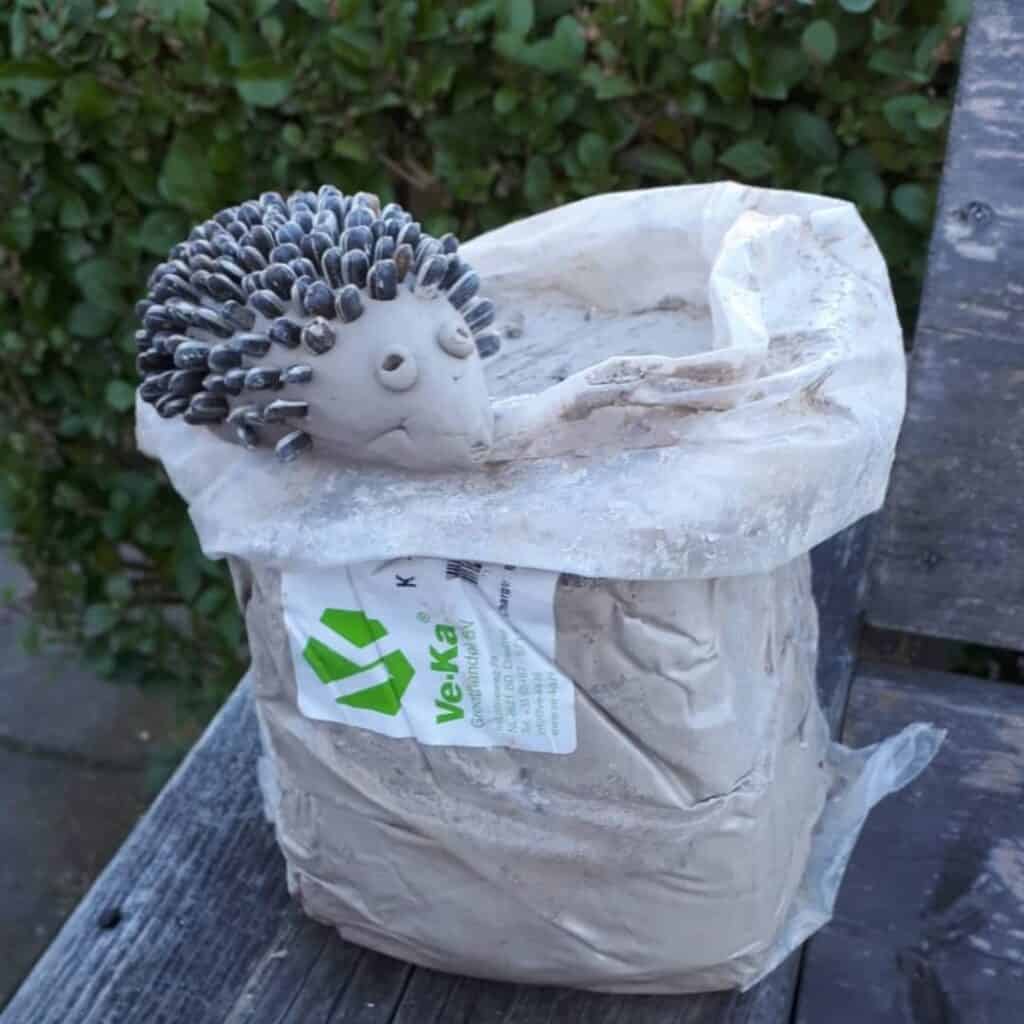 a clay hedgehog in a bag of sand